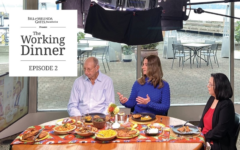 Keith Klugman, Melinda French Gates, and Anita Zaidi meet over dinner with guests Catherine Nyambura and Dr. Githinji Gitahi joining virtually on a television monitor