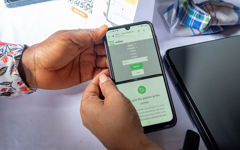 A user accesses the mDoc website on a smartphone during an outreach program at the Balogun Market in Lagos, Nigeria, on September 14, 2023. mDoc is a social enterprise that integrates proven methodologies in quality improvement and behavioral science with web and mobile-based technology to optimize the end to end care experience for people living with chronic health needs such as diabetes, hypertension, and cancer.